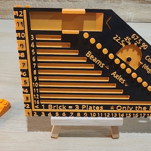 Black and orange brick ruler with a brick separator next to it.