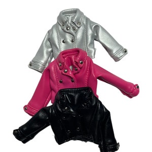 Pu&ograve; includere: Tre giacche in miniatura in argento, rosa acceso e nero. Ogni giacca ha un classico stile biker con colletto a revers, chiusure a scatto e dettagli argentati. Le giacche sono realizzate in un materiale lucido in ecopelle.