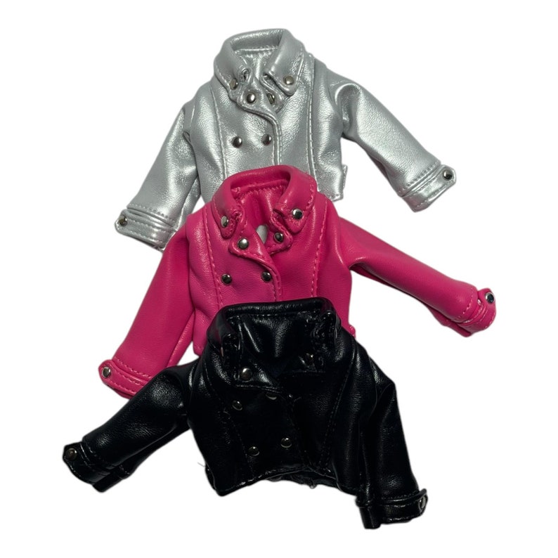 Pu&ograve; includere: Tre giacche in miniatura in argento, rosa acceso e nero. Ogni giacca ha un classico stile biker con colletto a revers, chiusure a scatto e dettagli argentati. Le giacche sono realizzate in un materiale lucido in ecopelle.