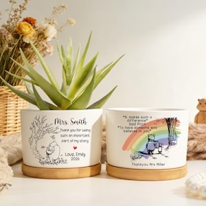 Könnte beinhalten: Zwei weiße Keramik-Pflanztöpfe mit Bambus-Untersetzern, jeweils mit einer Winnie-the-Pooh-Illustration und personalisiertem Text. Einer sagt "Mrs. Smith" und "Vielen Dank, dass Sie ein so wichtiger Teil meiner Geschichte sind."