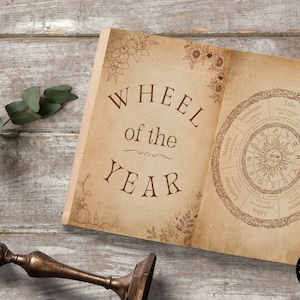 Pu&ograve; includere: Un libro aperto con una copertina marrone e un'illustrazione della ruota dell'anno. La ruota mostra gli otto sabbats dell'anno, tra cui Yule, Imbolc, Ostara, Beltane, Litha, Lammas, Mabon e Samhain. Il libro &egrave; su una superficie di legno.