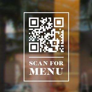 May include: A white rectangular window decal featuring a QR code at the top, enclosed within a thin white border. Below the QR code, the text SCAN FOR MENU is printed in a bold, white, serif font, separated by a horizontal line.