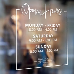 May include: White sign with black lettering on a glass door, displaying business hours. Open Hours: Monday - Friday 8:00 AM - 6:00 PM, Saturday 9:00 AM - 6:00 PM, Sunday 10:00 AM - 5:00 PM. Contact information: business_us, www.business site.com, us, 444, 444 5555.