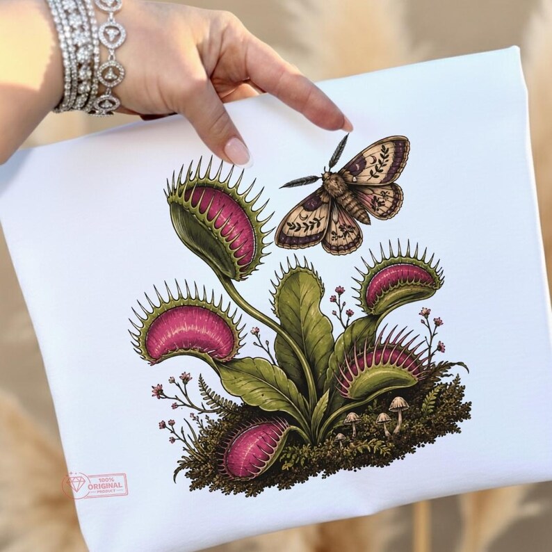 May include: A white canvas featuring a detailed illustration of a green Venus flytrap with vibrant pink interiors, surrounded by small mushrooms and moss. A moth with patterned wings is positioned above the plant. A small logo is in the corner.