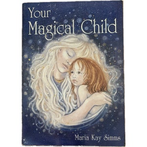 May include: A book cover with a blue background and stars. The cover features a painting of a woman with long blonde hair holding a young girl with red hair. The book title is "Your Magical Child" and the author is "Maria Kay Simms".