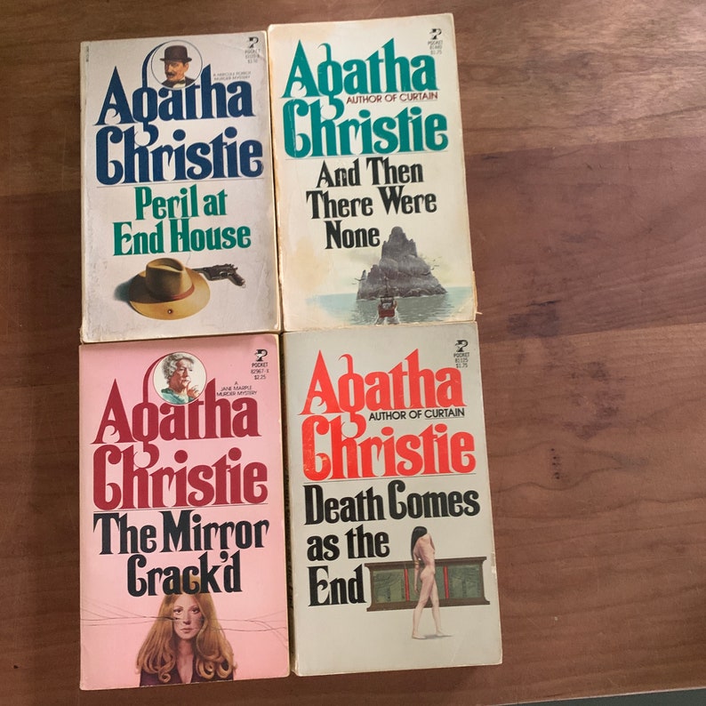 May include: Four paperback books by Agatha Christie. The titles are "Peril at End House", "And Then There Were None", "The Mirror Crack'd", and "Death Comes as the End".