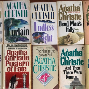 May include: A collection of ten paperback mystery novels by Agatha Christie. The books feature colorful covers with illustrations and titles such as "The Mirror Crack'd from Side to Side", "Curtain", "Endless Night", "Dead Man's Folly", "Mrs. McGinty's Dead", "Postern of Fate", "The Man in the Brown Suit", "And Then There Were None", and "Sleeping Murder".