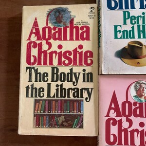 May include: Three paperback books by Agatha Christie. The first book is "The Body in the Library", the second is "Peril at End House", and the third is "The Mirror Crack'd from Side to Side".
