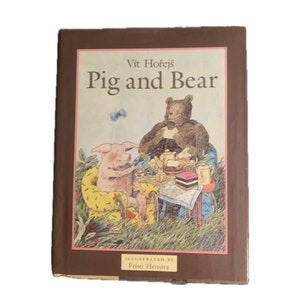 May include: A brown book cover with the title "Pig and Bear" by Vit Horejs. The cover features an illustration of a pig and a bear sitting at a table with a teapot and pastries. The text "Illustrated by Friso Henstra" is printed below the illustration.