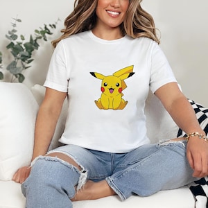 May include: A white t-shirt with a yellow cartoon character wearing a smile. The character has a lightning bolt shaped tail and is wearing a red cheek.