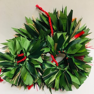 May include: Three green leaf wreaths with red accents. The wreaths are made of folded green leaves, with red cord and ribbon details. The leaves are arranged in a circular pattern, creating a natural and festive look.
