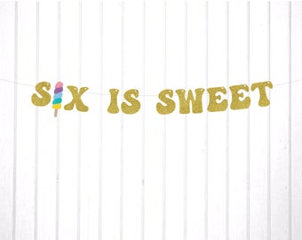 May include: Gold glitter banner with the text "Six is Sweet" and a colorful popsicle graphic.