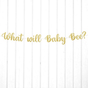 May include: Gold glitter banner with the text "What will Baby Bee?" and black bee silhouettes on each end.