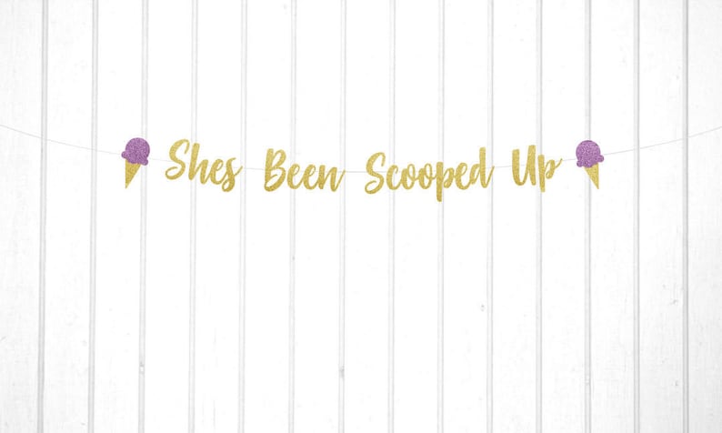 May include: Gold glitter banner with the text "She's Been Scooped Up" and two purple glitter ice cream cones on either end.