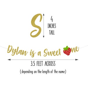 Op de afbeelding: Gouden glitterbanner met de tekst "Dylan is a Sweet One" en een rode en groene aardbeienafbeelding. De banner is 3,5 voet breed en 4 inch hoog.