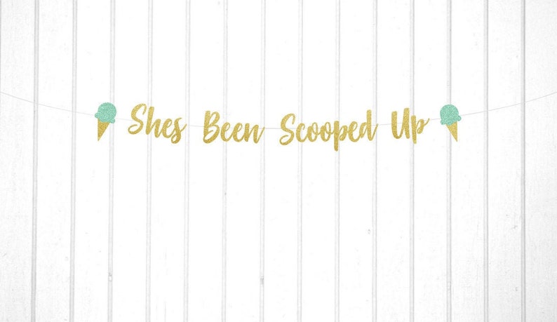 May include: Gold glitter banner with the text "She's Been Scooped Up" and two green ice cream cone cutouts.