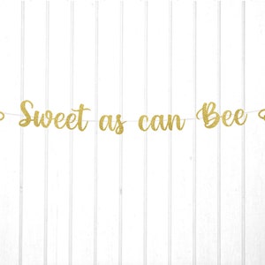 May include: Gold glitter banner with the text "Sweet as can Bee" and two bee cutouts on either end.