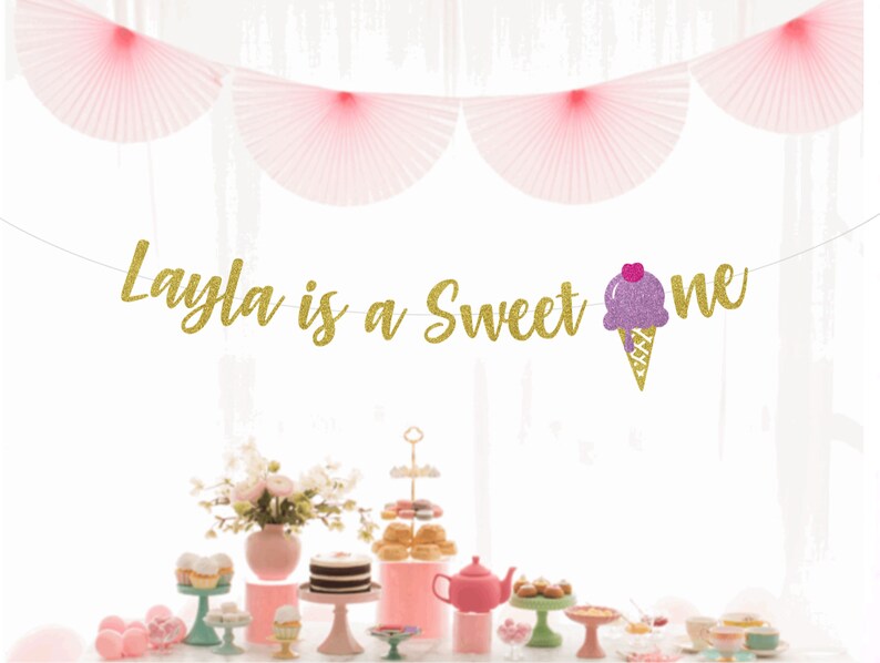 May include: Gold glitter banner with the text "Layla is a Sweet One" and a purple and pink ice cream cone graphic.