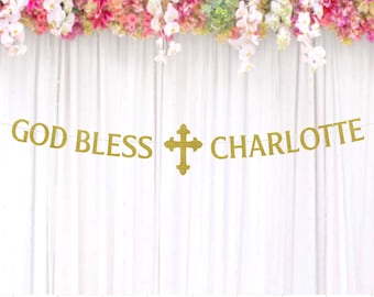 May include: Gold glitter banner with the text "God Bless Charlotte" and a gold glitter cross in the middle.