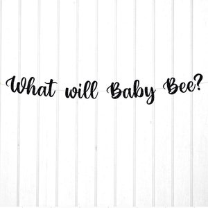 May include: A black and gold gender reveal banner with the text "What will Baby Bee?" and two gold glitter bee cutouts.
