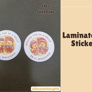 May include: Two round, laminated stickers with cartoon illustrations. Each sticker features a pair of cartoon characters in front of a door, with text in Spanish. The text "Laminated Stickers" is displayed on a light brown background.