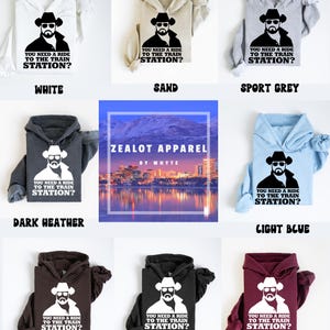 K&ouml;nnte beinhalten: Eine Auswahl an Hoodies in verschiedenen Farben, jeweils mit einer Grafik eines Mannes mit Cowboyhut und Sonnenbrille und dem Text "YOU NEED A RIDE TO THE TRAIN STATION?". Farben: Wei&szlig;, Sand, Sportgrau, Dunkelgrau, Hellblau, Dunkelbraun, Schwarz und Weinrot.
