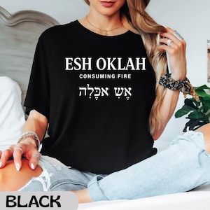 May include: Black t-shirt with the text "ESH OKLAH CONSUMING FIRE" in white. The text is in English and Hebrew. The shirt is a crew neck style.