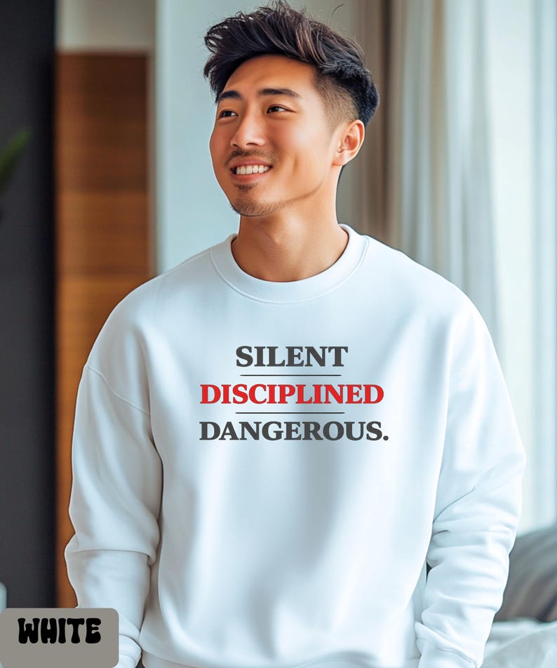 May include: White crew neck sweatshirt with the words "SILENT DISCIPLINED DANGEROUS." printed in black and red. The word "WHITE" is printed in a white box at the bottom left of the image.