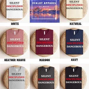 May include: A collection of t-shirts in various colors, including white, natural, heather mauve, maroon, navy, athletic heather, dark grey heather, and black. Each shirt features the text "SILENT DISCIPLINED DANGEROUS" in a bold font.