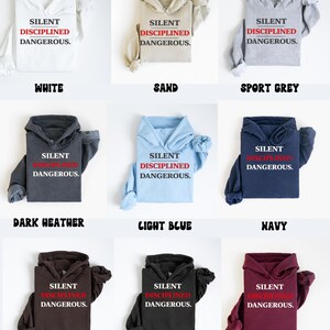 May include: A collection of hoodies in various colors, including white, sand, sport grey, dark heather, light blue, navy, dark chocolate, black, and maroon. Each hoodie displays the text "SILENT DISCIPLINED DANGEROUS."