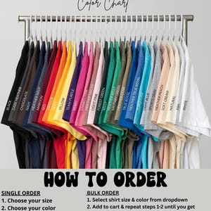 May include: A color chart of Bella Canvas 3001 t-shirts in various colors, including black, navy, red, yellow, and white, hanging on a metal rack. The text "Color Chart" and "How to Order" are also visible.