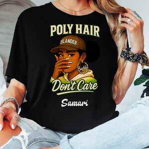 May include: Black t-shirt with the text "POLY HAIR" above an illustration of a person wearing a brown cap that says "Islander" and gold hoop earrings that say "Baddie". The text "Don't Care" is below the illustration, and the name "Samari" is at the bottom.