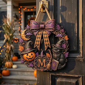 Pode incluir: Uma guirlanda decorativa de Halloween com um grande laço roxo com padrão de losangos, uma abóbora sorridente com chapéu de bruxa, um gato preto com chapéu de bruxa, uma vassoura, um livro de feitiços, uma lua crescente e a letra M no centro.