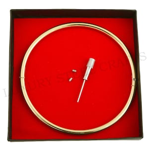 May include: A gold-coloured metal choker necklace in a red velvet box with a small screwdriver and two screws.