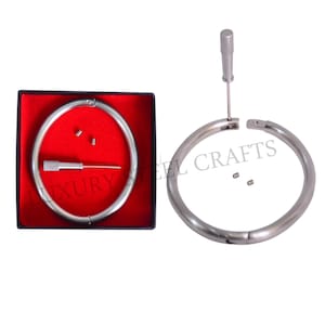 Op de afbeelding: Een roestvrijstalen ring met schroefsluiting, gepresenteerd in een zwarte doos met een rode binnenkant. De doos bevat de ring, een kleine schroevendraaier en twee kleine schroeven. De tekst "LUXURY STEEL CRAFTS" is zichtbaar.