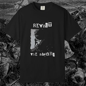 May include: Black t-shirt with the words "REVOLT" and "THE absurD" in a distressed font. The shirt features a grayscale graphic of a figure. The shirt is made of a soft material.