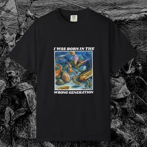 May include: Black t-shirt featuring a graphic print of a colourful underwater scene with the text "I was born in the wrong generation".