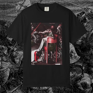 May include: Black t-shirt featuring a print of a Hieronymus Bosch painting. The artwork depicts a surreal scene with figures in a hellish landscape. The shirt has a classic crew neck and short sleeves. The shirt is made of a soft, comfortable material.