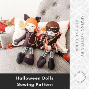 May include: Sewing pattern for two Halloween dolls. One doll is dressed as a black cat with orange hair and a black and white striped dress. The other doll is dressed as a bat with a black mask, a plaid dress, and black and white striped leggings. The pattern is by Hen and Chick.