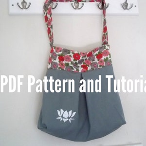 May include: A gray tote bag with a floral print lining and a white lotus flower design. The bag has a long strap and is hanging on hooks. The text *PDF Pattern and Tutorial* is visible below the bag.