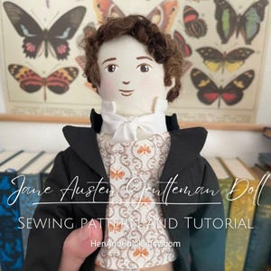 May include: A handmade doll dressed in a black jacket, white shirt, and patterned vest. The doll has brown hair and a friendly face. The doll is labeled "Jane Austen Gentleman Doll Sewing Pattern and Tutorial".