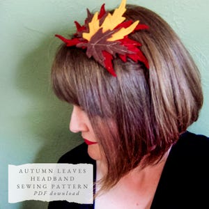 May include: A headband featuring a cluster of fabric autumn leaves in shades of red, yellow, and brown. The text on the image reads: AUTUMN LEAVES HEADBAND SEWING PATTERN PDF download. The leaves are layered and stitched to create a decorative accessory.