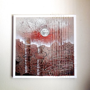 May include: Abstract art print with a textured background in shades of brown, red, and white. The print features a circular shape in the center and a grid pattern with white stitching.