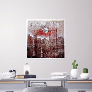 May include: A framed abstract painting with a red, white, and brown color scheme. The painting features a circular shape in the center and a grid-like pattern throughout.