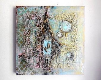 Op de afbeelding: Abstract mixed media kunstwerk op een vierkant canvas. Het stuk heeft een textuur oppervlak met een palet van lichtblauw, goud, roze en bruin. Het ontwerp bevat cirkelvormige en geometrische vormen.