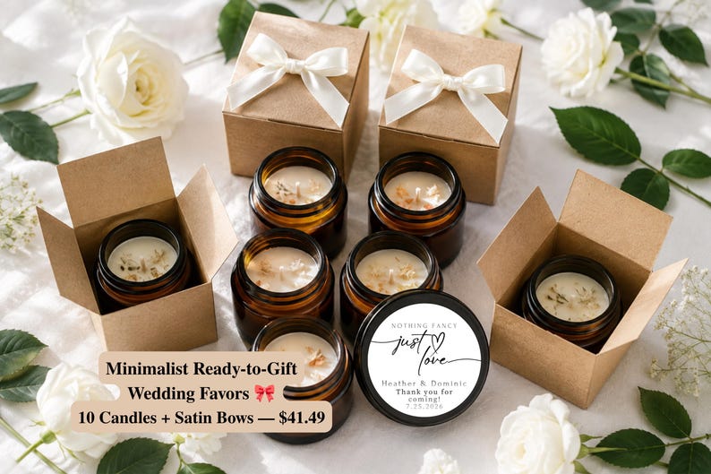 May include: Several amber glass candle jars filled with white wax, some placed inside open brown cardboard boxes with white satin bows. One black candle lid features the text: Nothing Fancy, just love, Heather & Dominic, Thank you for coming, 7.25.2026.
