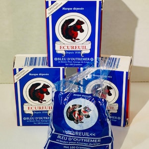 May include: Blue and white boxes and a bag of blue laundry balls. The boxes feature a red squirrel illustration inside a white circle, with the text "ECUREUIL" and "BLEU D'OUTREMER." The bag also displays the squirrel logo and text.