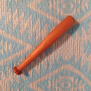 May include: A wooden baseball bat with a rounded end. The bat is a light brown color and has a smooth finish.