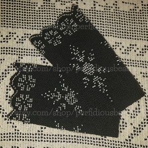 Puede incluir: Un par de calentadores de muñeca de crochet negro con un diseño de cuentas. Los calentadores tienen un borde festoneado y están decorados con cuentas plateadas.