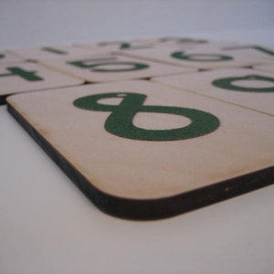 Puede incluir: Azulejos de madera con n&uacute;meros verdes sobre un fondo blanco. Los n&uacute;meros son 1, 2, 3, 4, 5, 6, 7, 8 y 9.